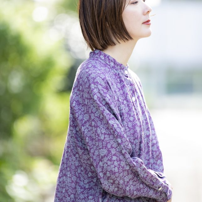 風合い豊かなリネンに乗せた特別なリバティ生地で作られたブラウスを着用したモデル写真